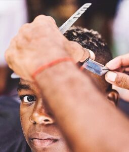 (Foto:Fernando Schlaepfer) Barbeiro cortando o cabelo de um garoto