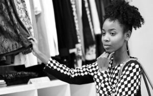 jovem negra visualizando uma arara de roupas - artigo Hábitos (A Serem Evitados) Para Liberdade Financeira